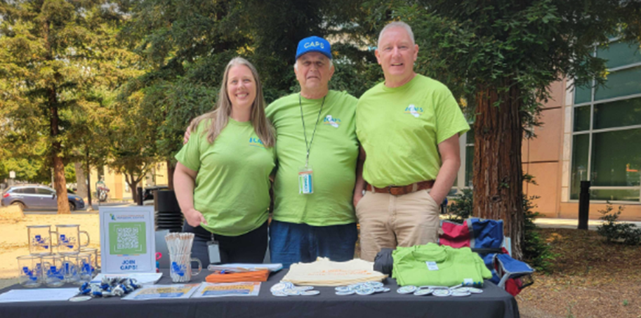 CAPS-UAW organizing team tabling outdoors with union shirts and swag.